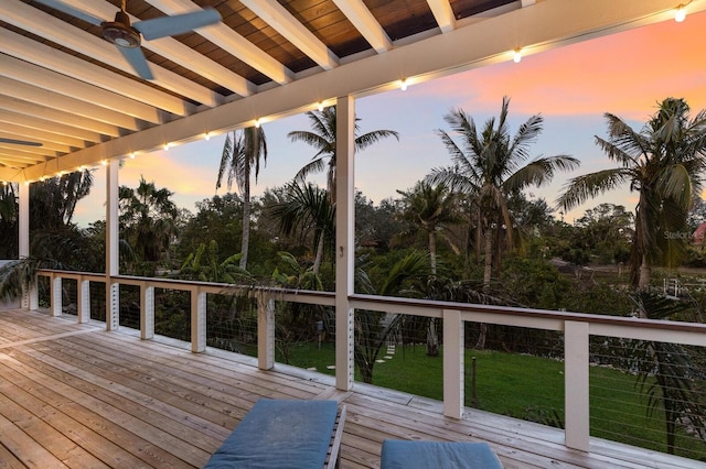 deck at dusk featuring ceiling fan