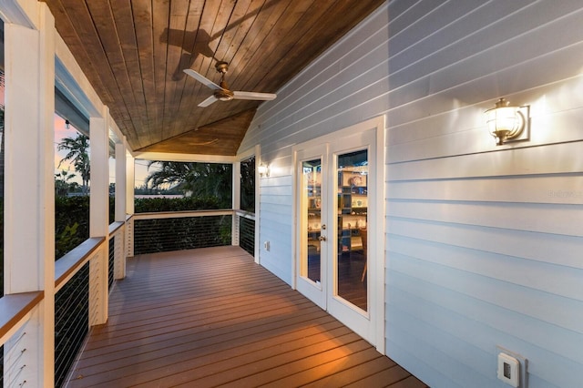 deck at dusk with ceiling fan, french doors, and a porch