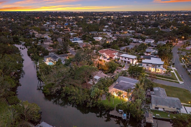 aerial view at dusk featuring a water view