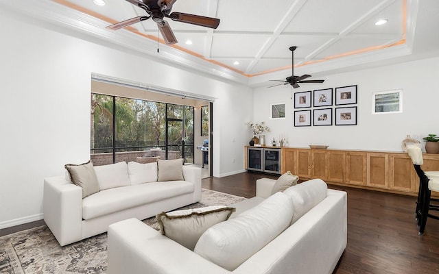 living room with coffered ceiling, ceiling fan, dark wood-type flooring, indoor bar, and crown molding