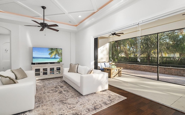 living room with hardwood / wood-style floors, beamed ceiling, ornamental molding, ceiling fan, and coffered ceiling