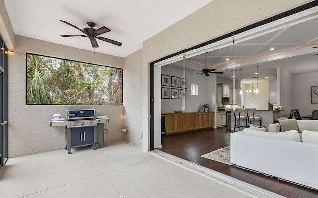 living room with ceiling fan with notable chandelier