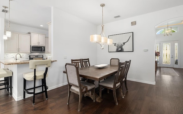 dining area with a notable chandelier and dark hardwood / wood-style floors