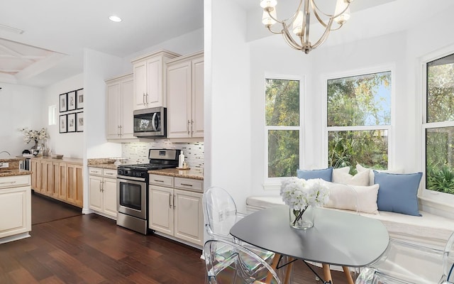 kitchen with stainless steel appliances, decorative backsplash, dark wood-type flooring, pendant lighting, and light stone counters