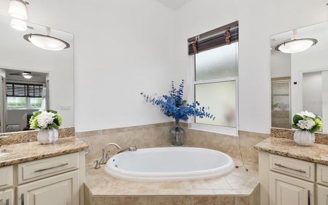 bathroom featuring tiled bath and vanity