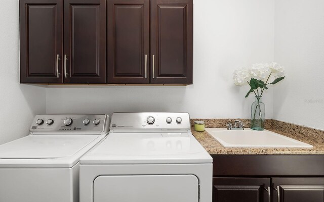 laundry room featuring cabinets, sink, and independent washer and dryer