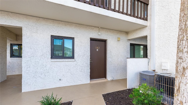 entrance to property with cooling unit and a balcony