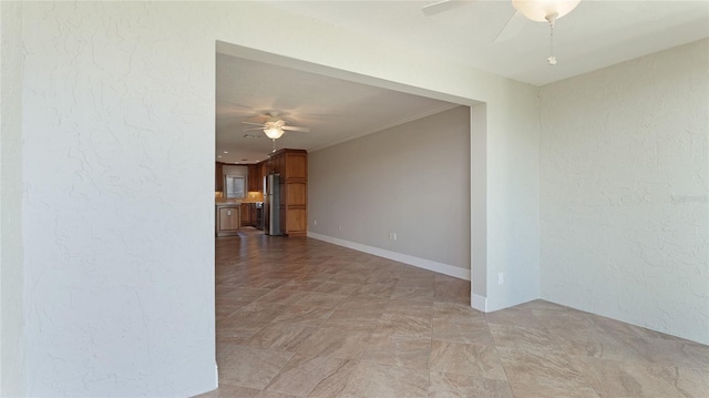 spare room featuring ceiling fan and ornamental molding