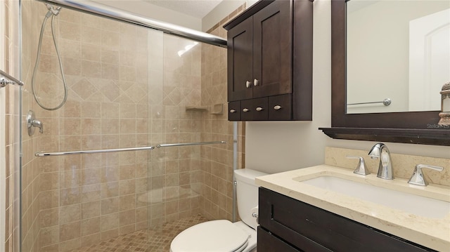 bathroom featuring vanity, toilet, and a shower with shower door