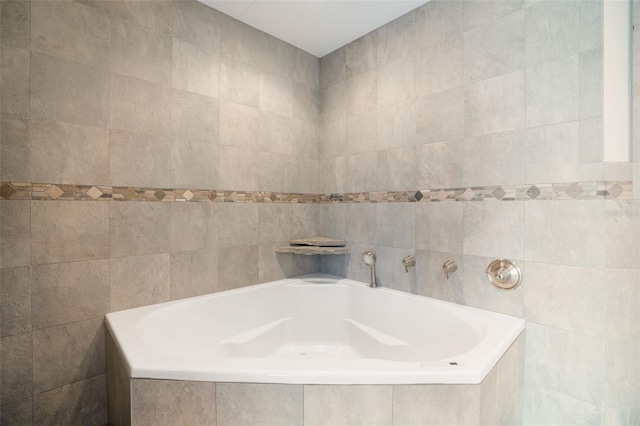 bathroom with tiled tub and tile walls