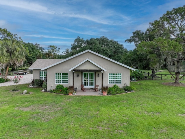 single story home with a front lawn and french doors