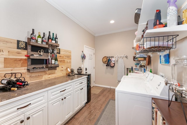 laundry area featuring dark hardwood / wood-style floors, ornamental molding, and washing machine and dryer