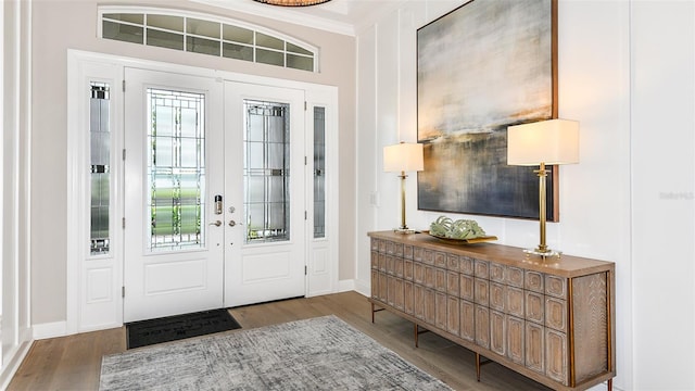 entrance foyer with crown molding and wood-type flooring