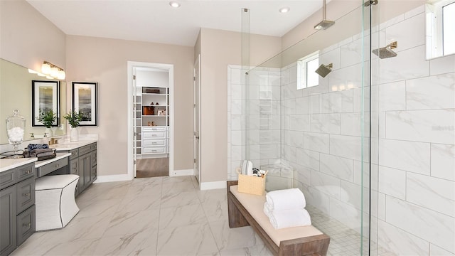 bathroom with a tile shower and vanity