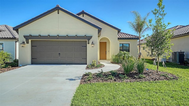 view of front of house featuring cooling unit, a garage, and a front yard