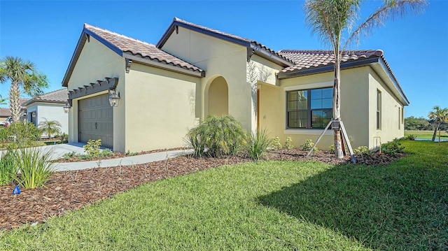 mediterranean / spanish-style home with a garage and a front yard