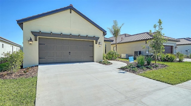 view of front of property featuring a front lawn, a garage, and central air condition unit