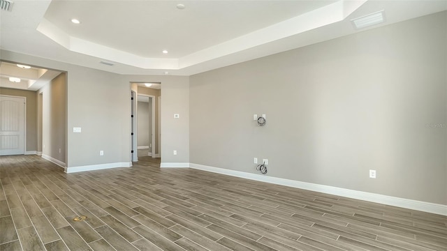 unfurnished room featuring a raised ceiling