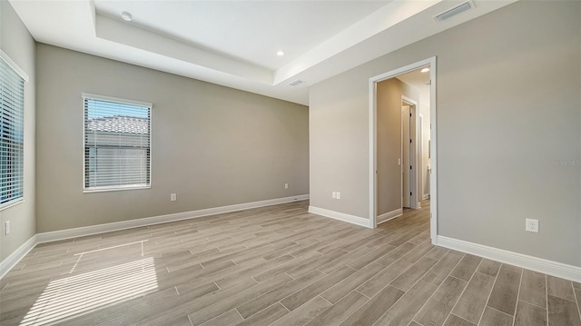 spare room with a raised ceiling