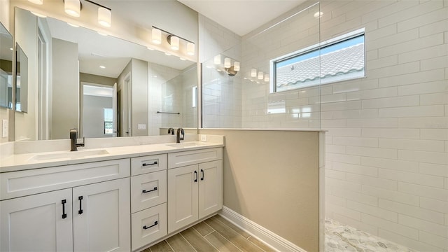 bathroom with vanity and a tile shower