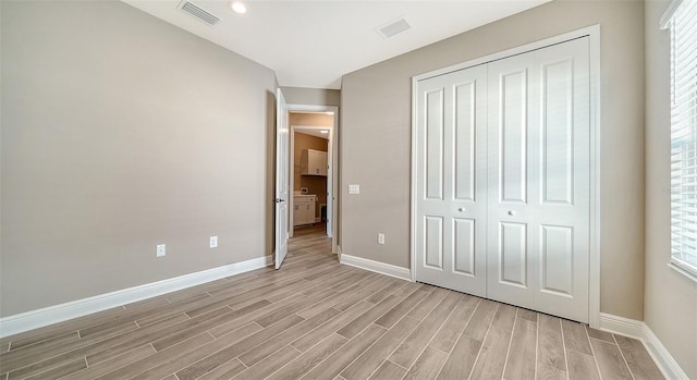 unfurnished bedroom with a closet and multiple windows