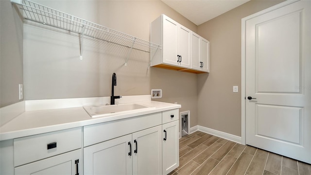 laundry room featuring washer hookup, cabinets, and sink