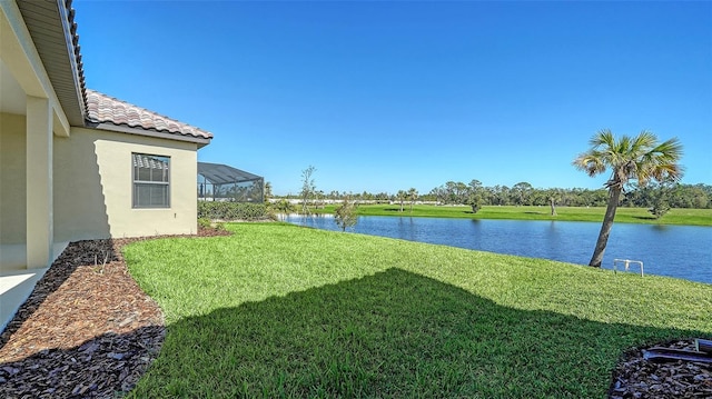 view of yard featuring glass enclosure and a water view