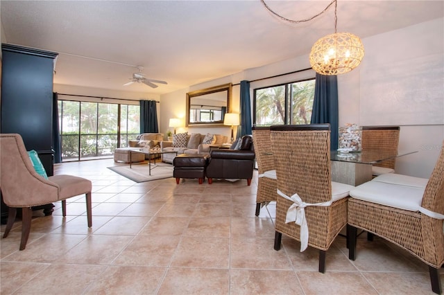 dining space with ceiling fan with notable chandelier and light tile patterned floors