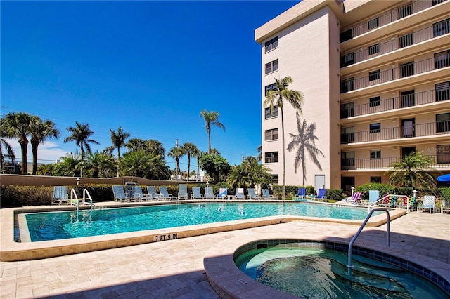 view of swimming pool featuring a hot tub