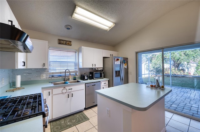 kitchen with sink, light tile patterned floors, white cabinetry, stainless steel appliances, and vaulted ceiling