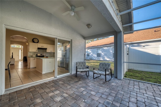 unfurnished sunroom with vaulted ceiling and ceiling fan