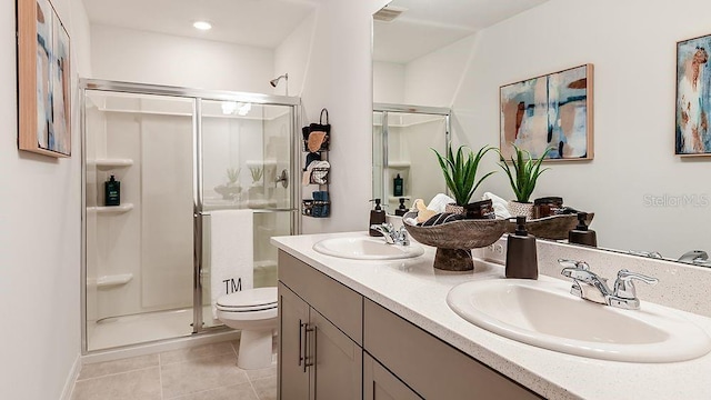 bathroom with toilet, vanity, tile patterned floors, and a shower with door