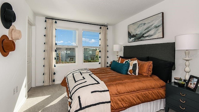 bedroom featuring a textured ceiling and light colored carpet