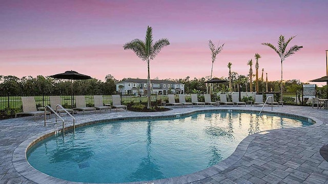 pool at dusk with a patio