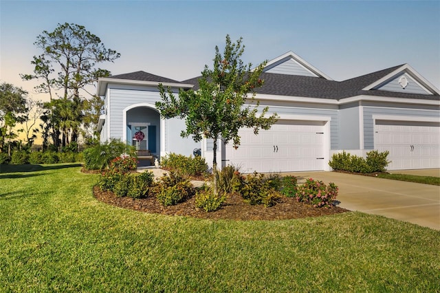 view of front of house featuring a garage and a lawn