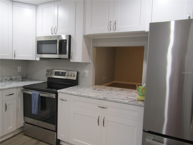 kitchen with light stone counters, stainless steel appliances, wood-type flooring, and white cabinets