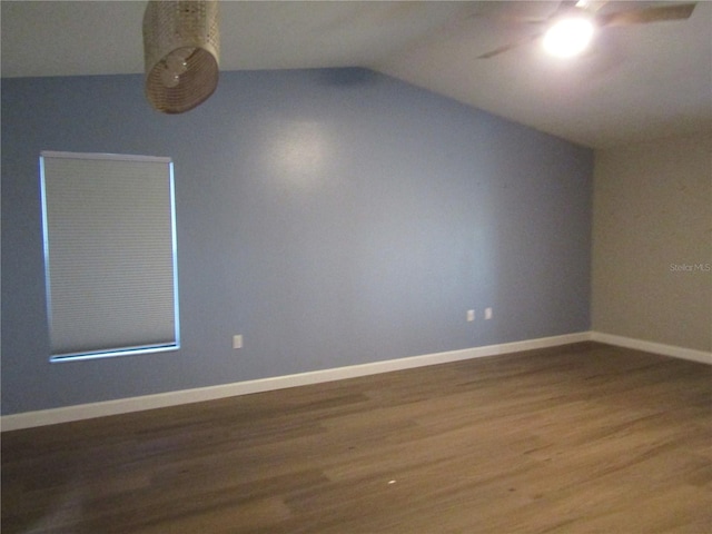 spare room featuring hardwood / wood-style floors, vaulted ceiling, and ceiling fan