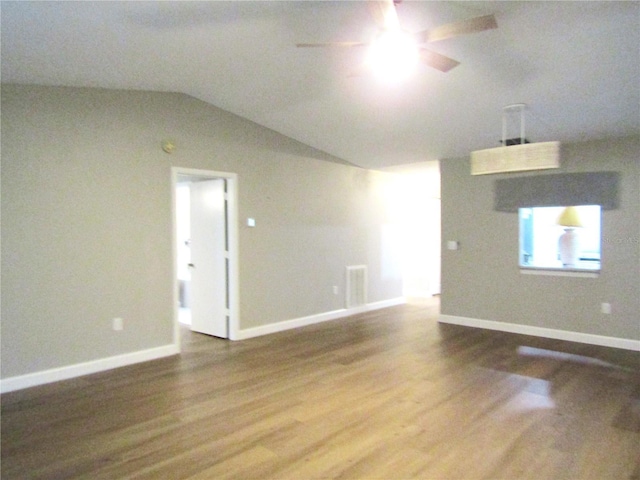 empty room with hardwood / wood-style flooring, vaulted ceiling, and ceiling fan