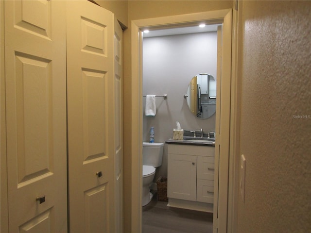 bathroom featuring hardwood / wood-style flooring, vanity, and toilet