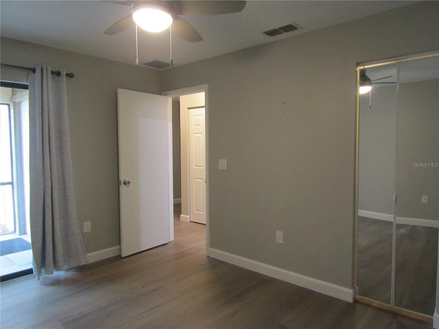 unfurnished bedroom featuring ceiling fan, a closet, and multiple windows