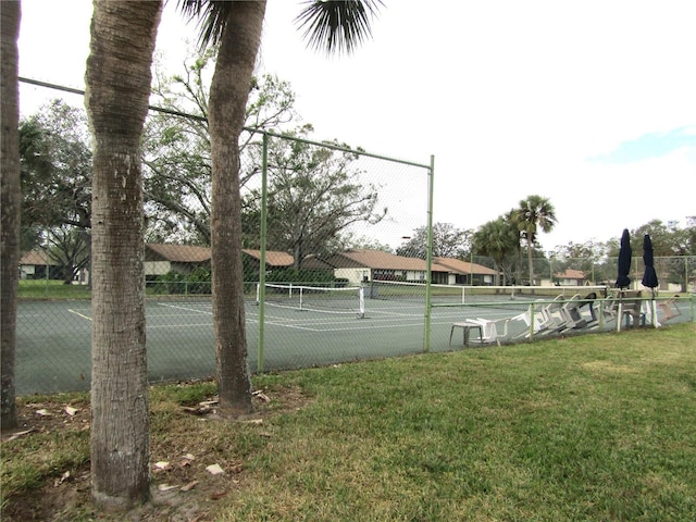 view of tennis court featuring a yard