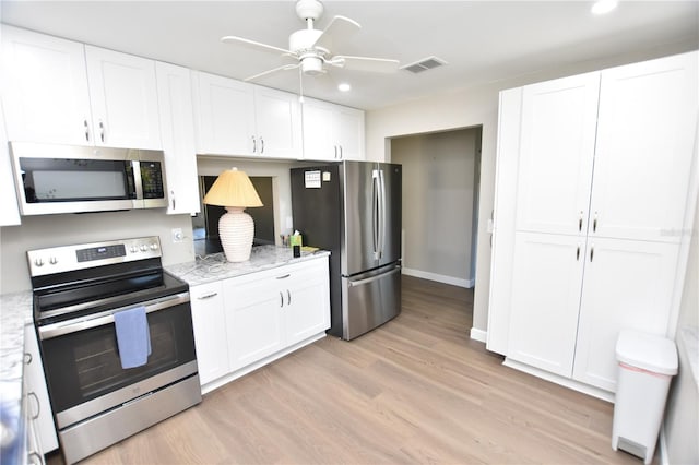 kitchen with white cabinetry, stainless steel appliances, and light wood-type flooring