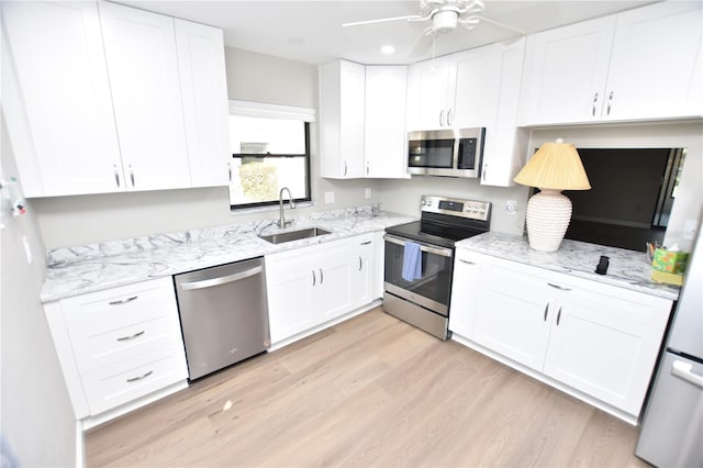 kitchen with stainless steel appliances, white cabinetry, and sink