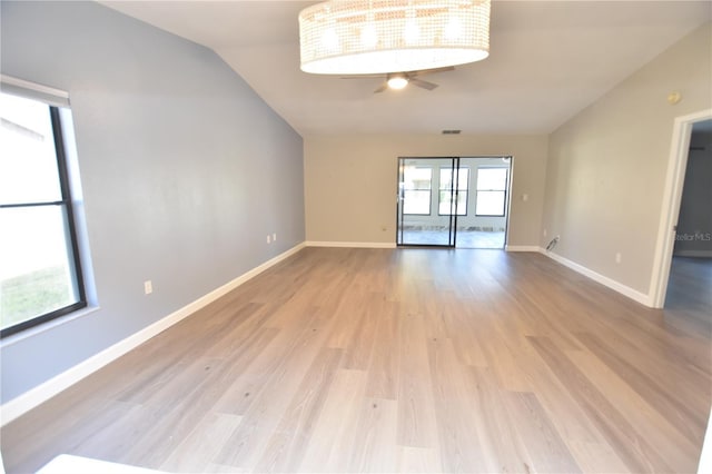 spare room with lofted ceiling, plenty of natural light, and light wood-type flooring