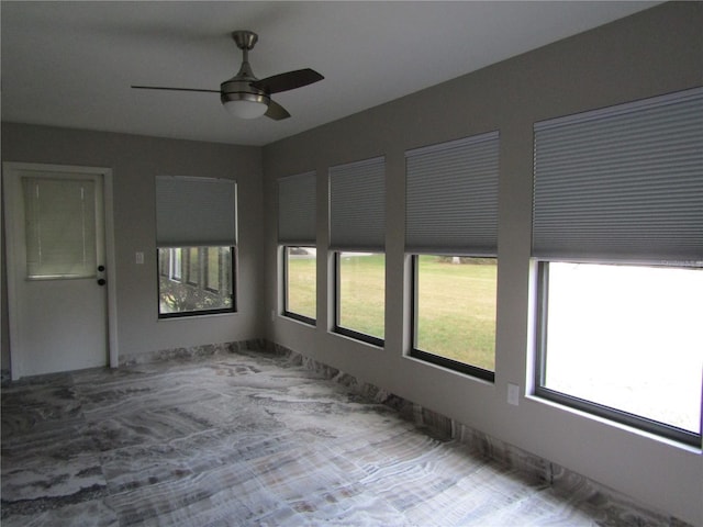 unfurnished sunroom featuring ceiling fan