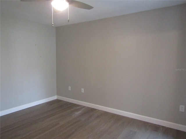 spare room featuring dark wood-type flooring and ceiling fan