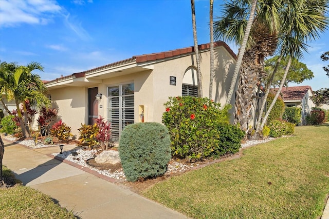 mediterranean / spanish home featuring a front lawn