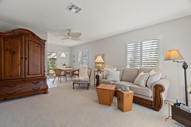 carpeted living room with ceiling fan