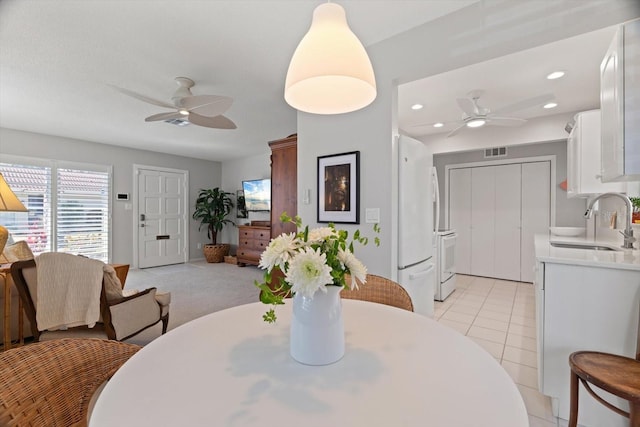 dining room with light tile patterned flooring, sink, and ceiling fan