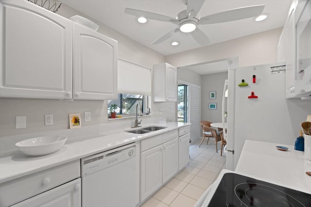 kitchen featuring sink, white appliances, light tile patterned floors, ceiling fan, and white cabinets